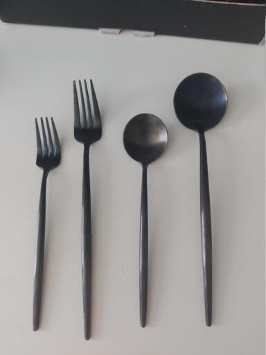 4 black utensils with long thin handles. Small fork, Big fork, small spoon, big spoon.

The spoons have a completely circular head.