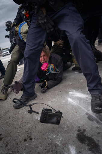 Photographer John Abernathy throwing his Leica while being tackled by ICE and CBP in Minneapolis. Photo by Pierre Lavie